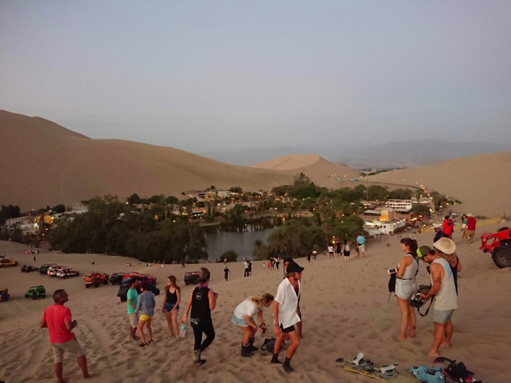 Evening vibe by the oasis on the tourist route. Huacachina Oasis, Peru.
